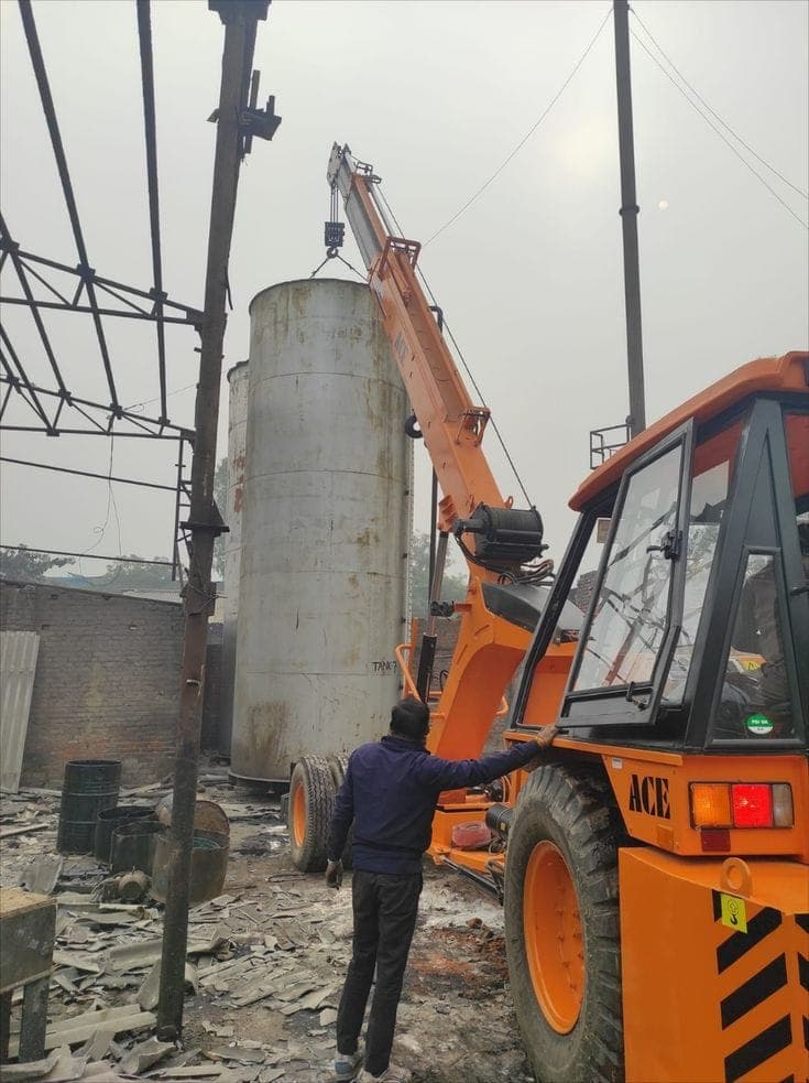 Crane lifting an industrial tank at a plant
